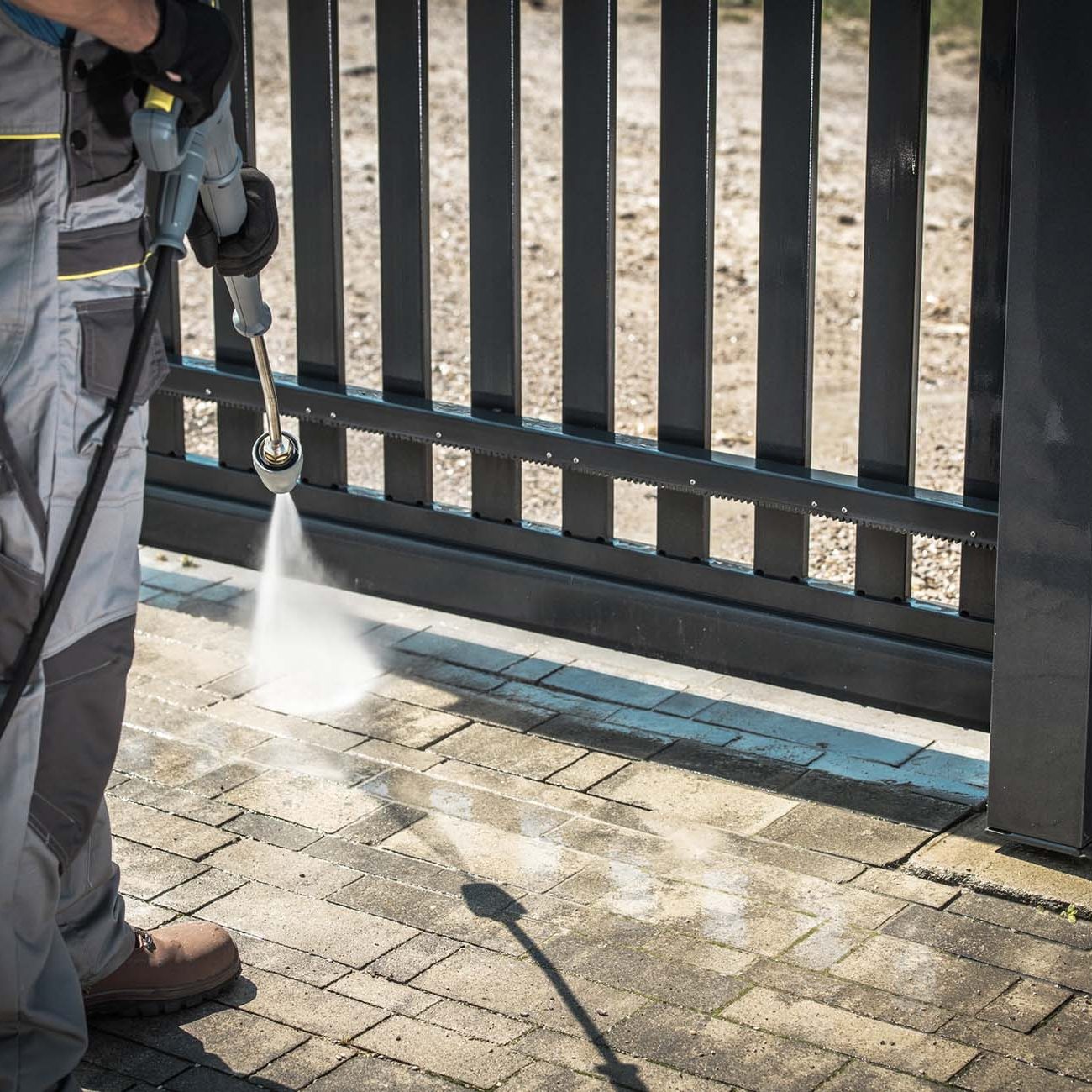 Driveway and a Gate Pressure Washing. Cleaning House Surroundings